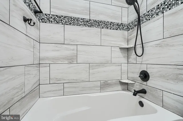 an empty room with wooden floor fireplace and windows