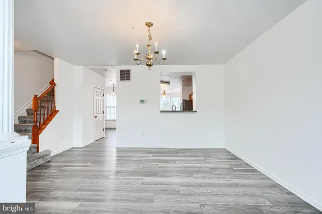 a view of a livingroom with wooden floor and a ceiling fan