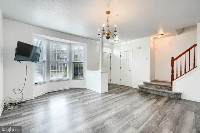 a view of a livingroom with wooden floor and a flat screen tv