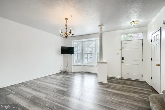 a view of a kitchen with wooden floor and a refrigerator