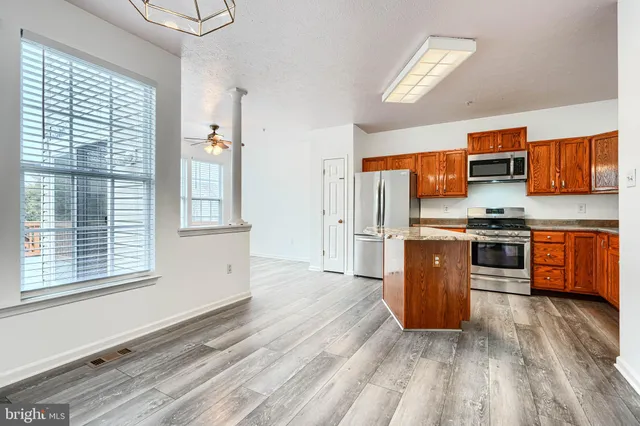 a kitchen with stainless steel appliances granite countertop a stove a sink and a refrigerator