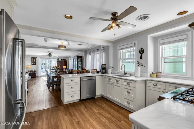a kitchen with granite countertop a sink stainless steel appliances and cabinets