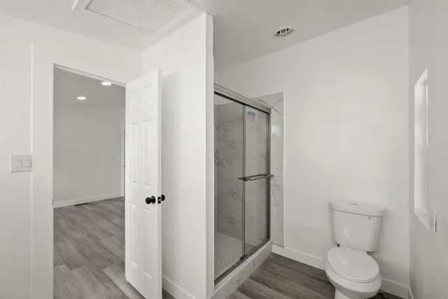 a bathroom with a toilet and a shower