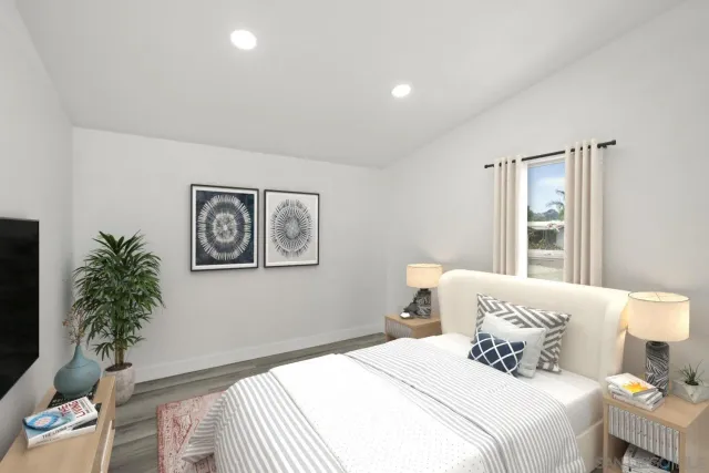 a bedroom with a large bed and a potted plant