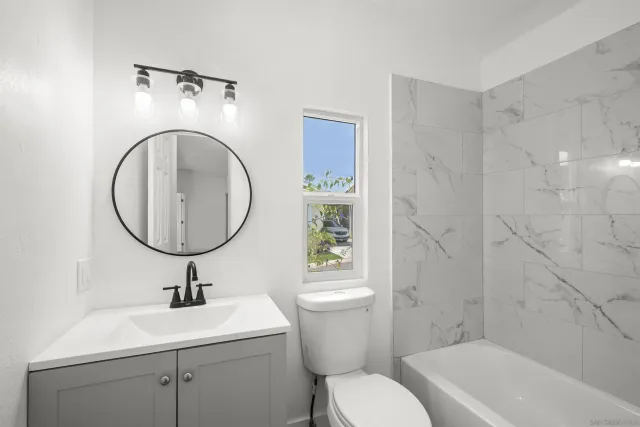 a bathroom with a sink a toilet and a mirror