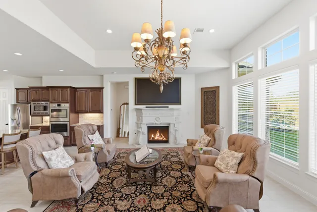 a living room with furniture a fireplace and a chandelier