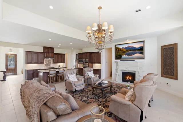 a living room with furniture chandelier and a large window