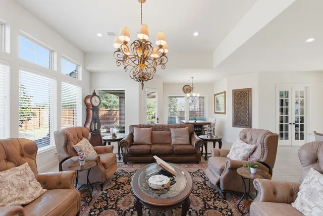 a living room with furniture large window and dining table