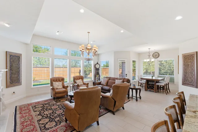 a dining room with wooden floor a chandelier a wooden table and chairs