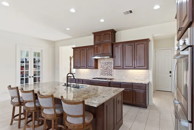 a kitchen with stainless steel appliances granite countertop a sink stove and refrigerator