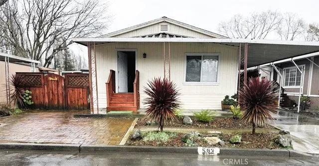 a view of a small house with a small yard and potted plants