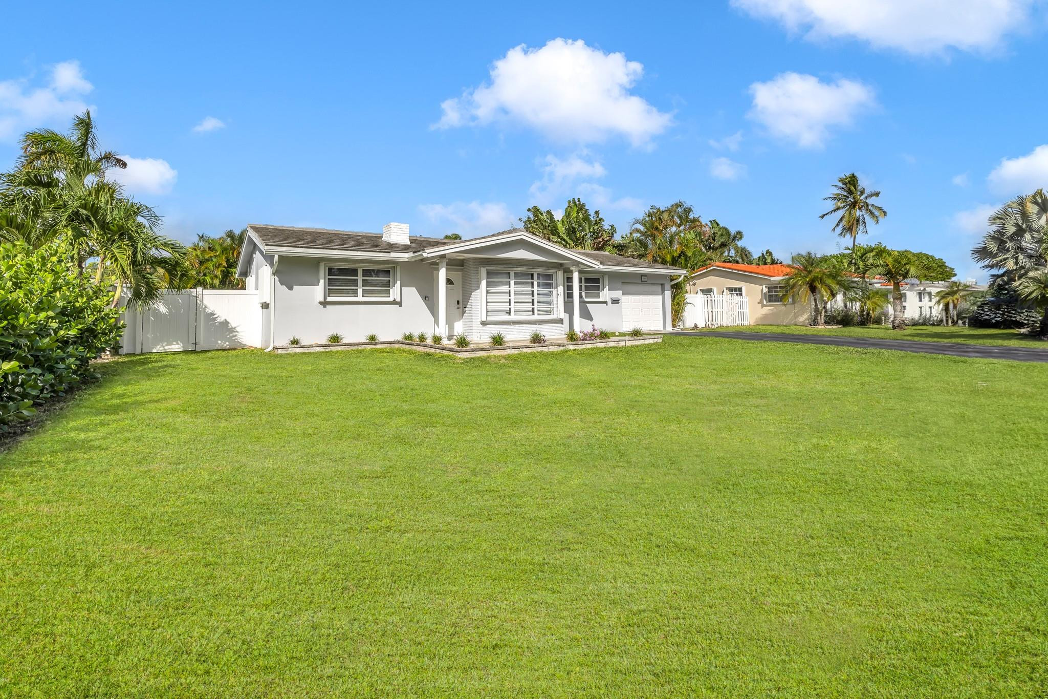 5211 Northeast 26th Avenue Lighthouse Point, FL 33064 - Photo 1 of 33 a front view of a house with a garden