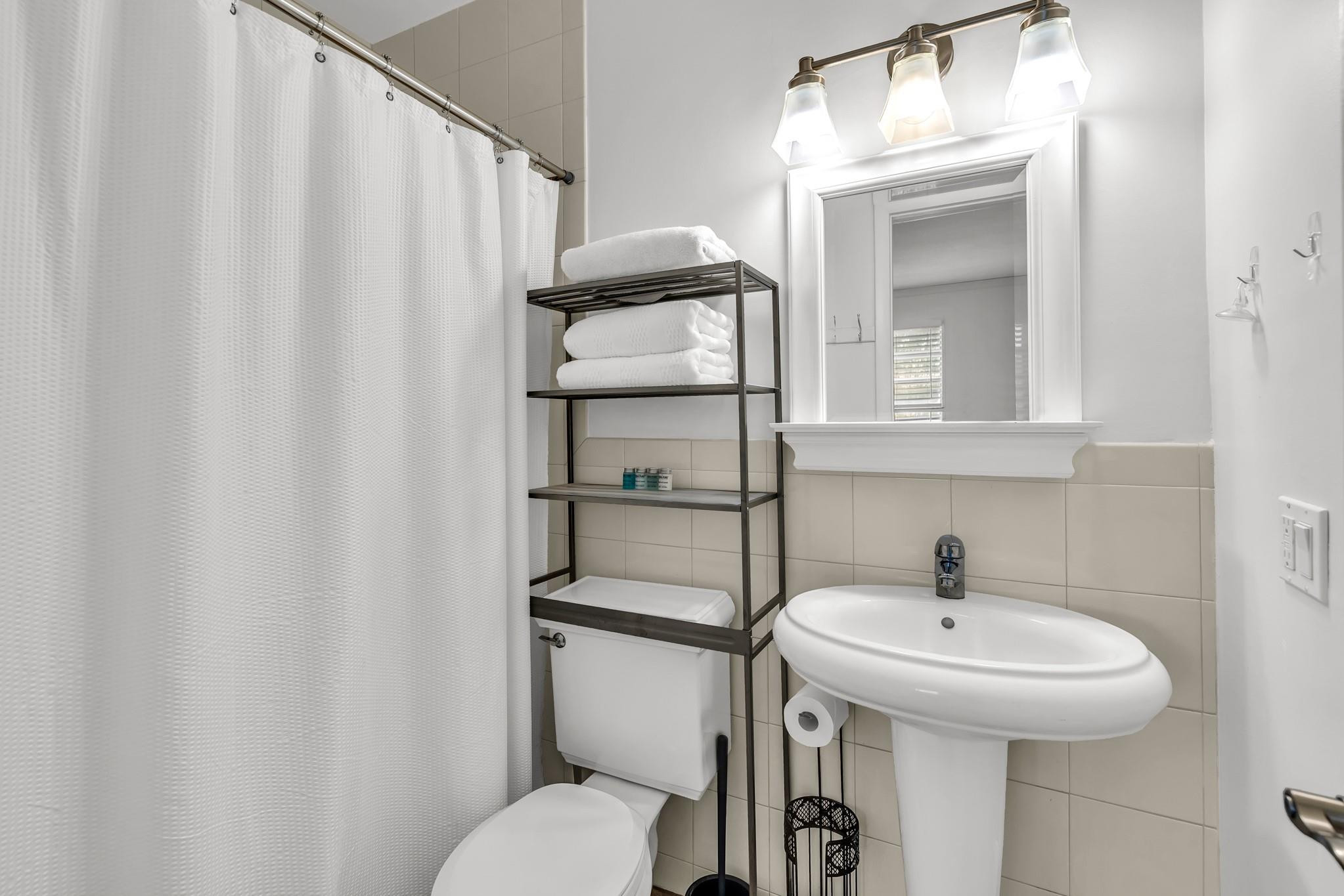 5211 Northeast 26th Avenue Lighthouse Point, FL 33064 - Photo 29 of 33 a bathroom with a sink toilet and mirror