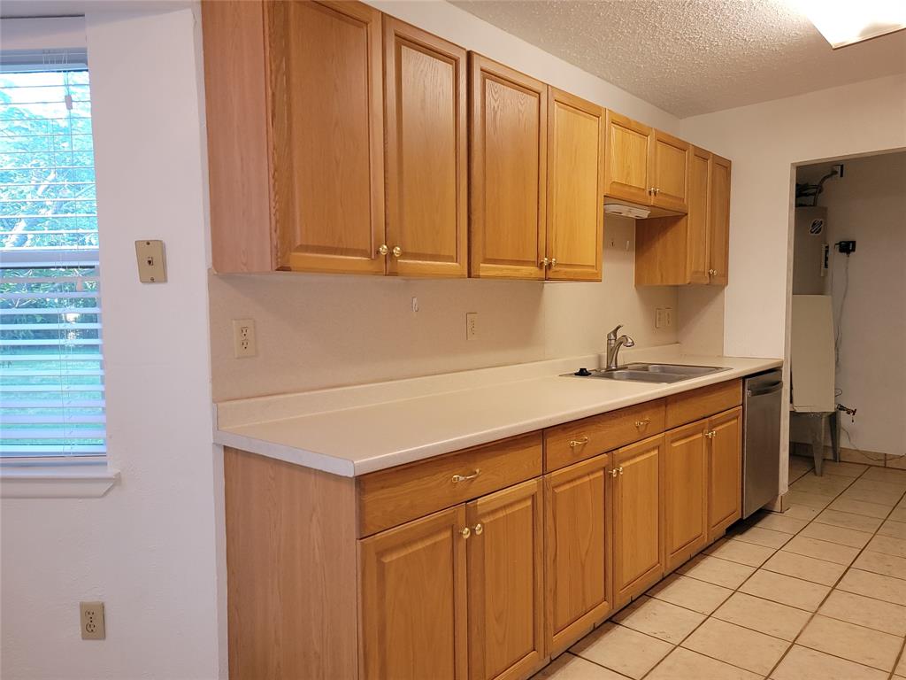 1000 Springdale Road Bedford, TX 76021 - Photo 5 of 36 This kitchen has many built-in cabinets for your storage needs! The separate utility room has space for your favorite full size washer and dryer and water heater access.