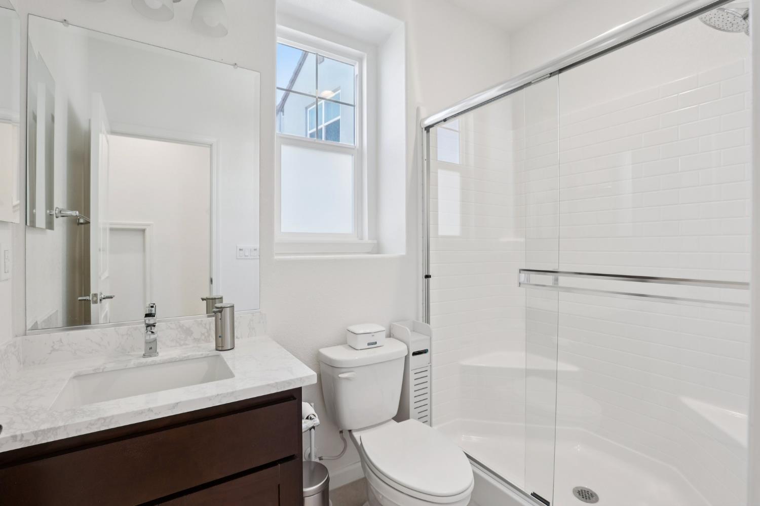 2413 Seaside Road Lathrop, CA 95330 - Photo 15 of 37 a bathroom with a sink a toilet and shower