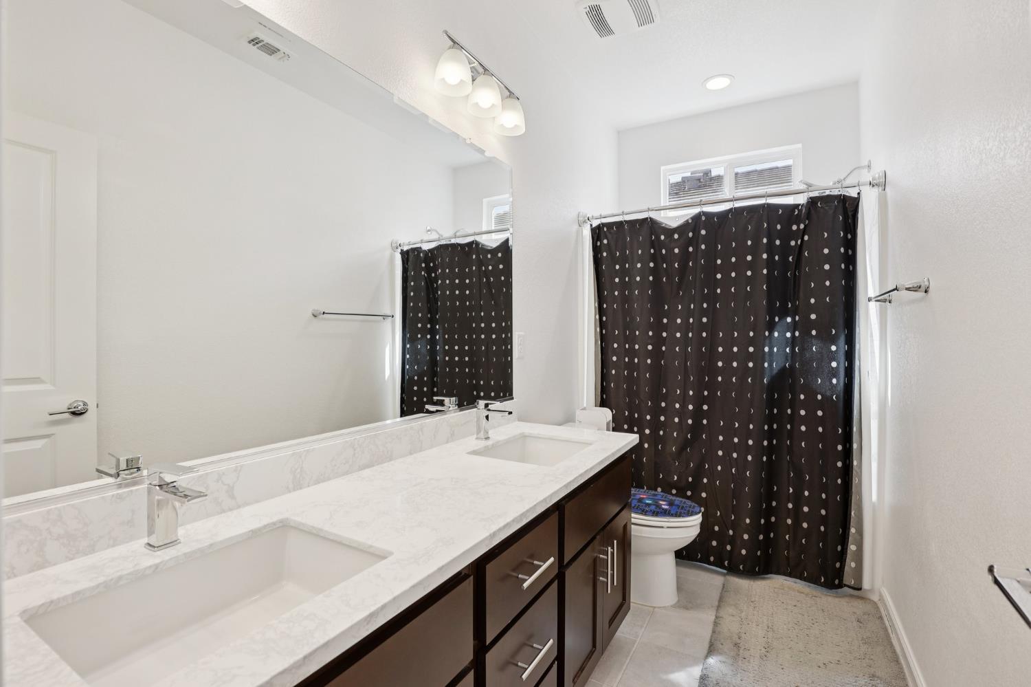2413 Seaside Road Lathrop, CA 95330 - Photo 23 of 37 a bathroom with a sink double vanity and a shower