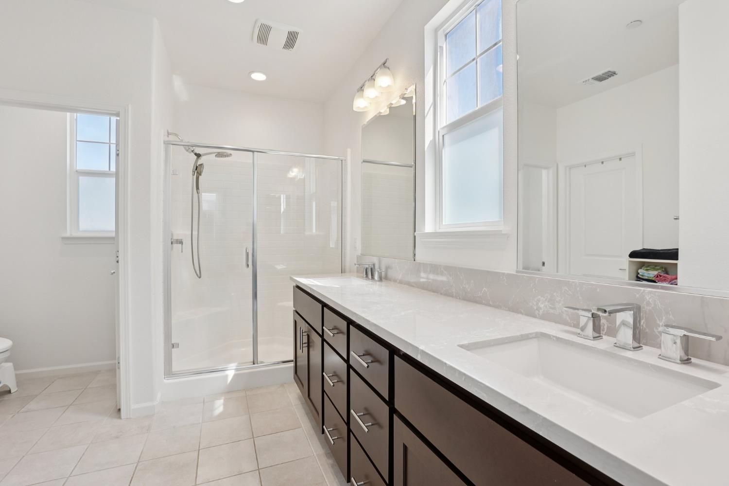 2413 Seaside Road Lathrop, CA 95330 - Photo 26 of 37 a bathroom with a granite countertop sink a shower and a mirror