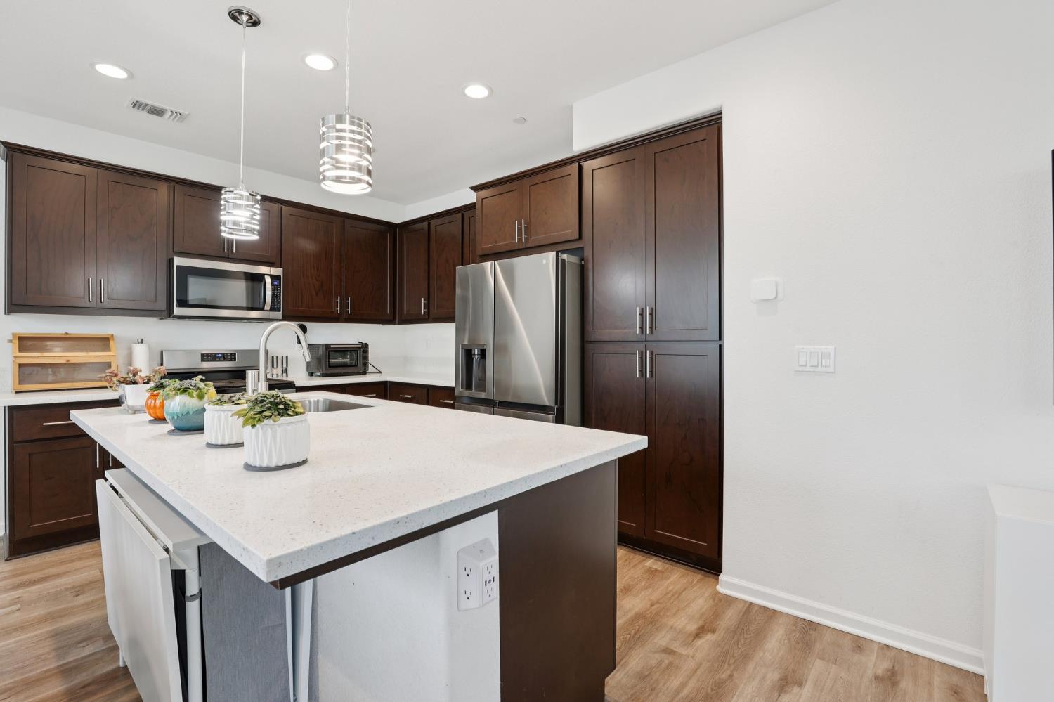 2413 Seaside Road Lathrop, CA 95330 - Photo 9 of 37 a kitchen with stainless steel appliances granite countertop a refrigerator a sink a stove a microwave and island