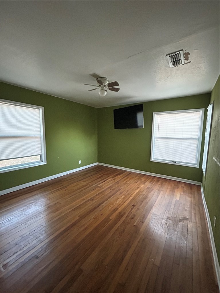 1041 East 5th Street Alice, TX 78332 - Photo 13 of 19 an empty room with wooden floor and windows