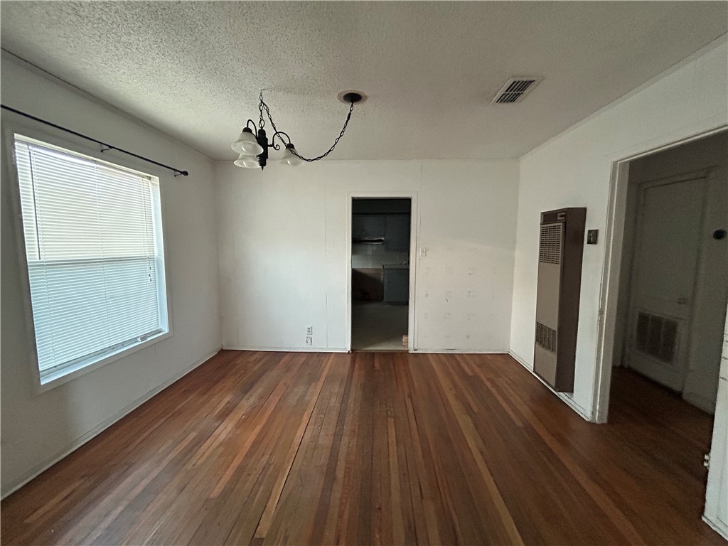 1041 East 5th Street Alice, TX 78332 - Photo 4 of 19 an empty room with wooden floor cabinet and windows