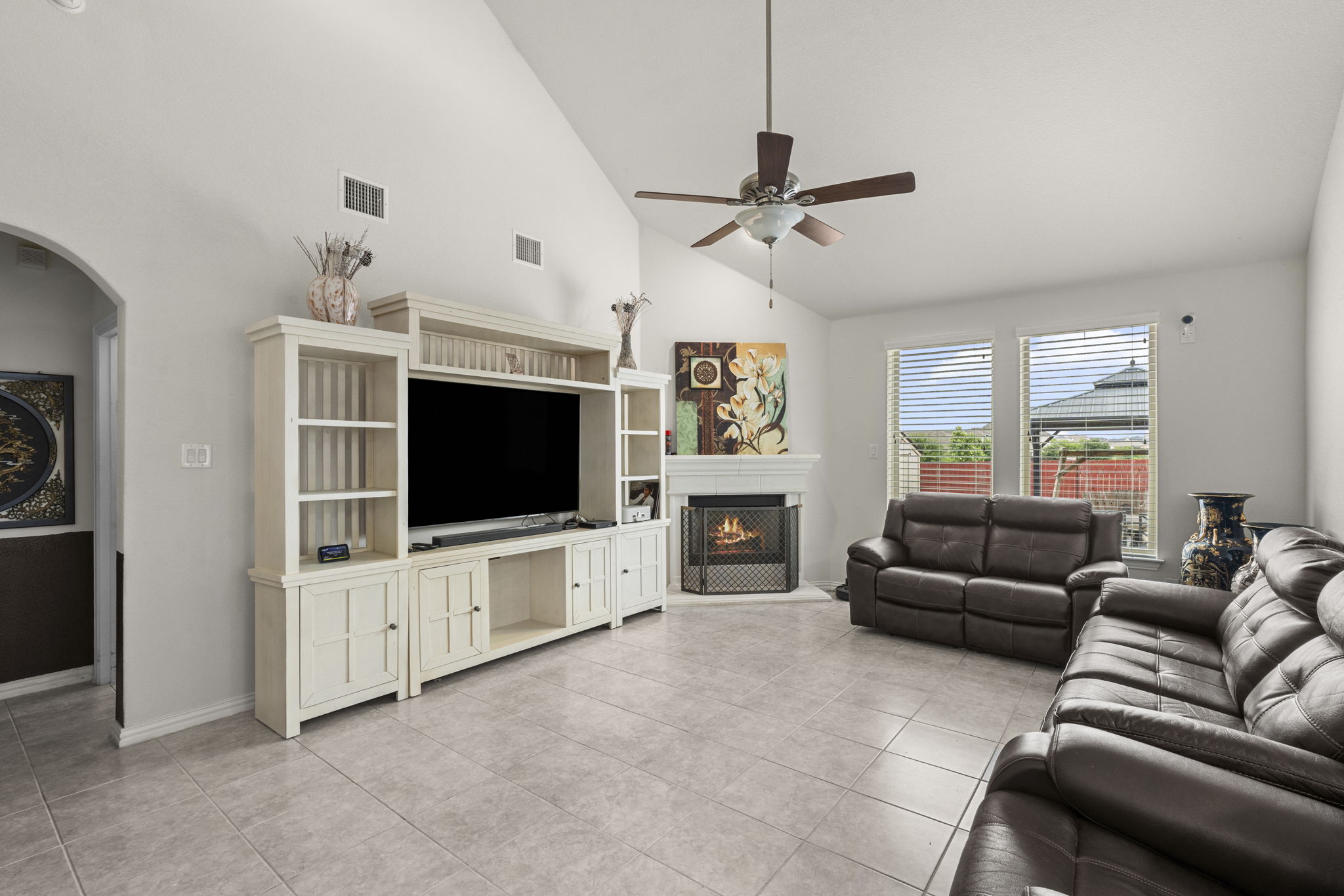 373 Rough Bark Street Buda, TX 78610 - Photo 9 of 39 Vast vaulted ceilings and a warm corner fireplace enhance this inviting living space.