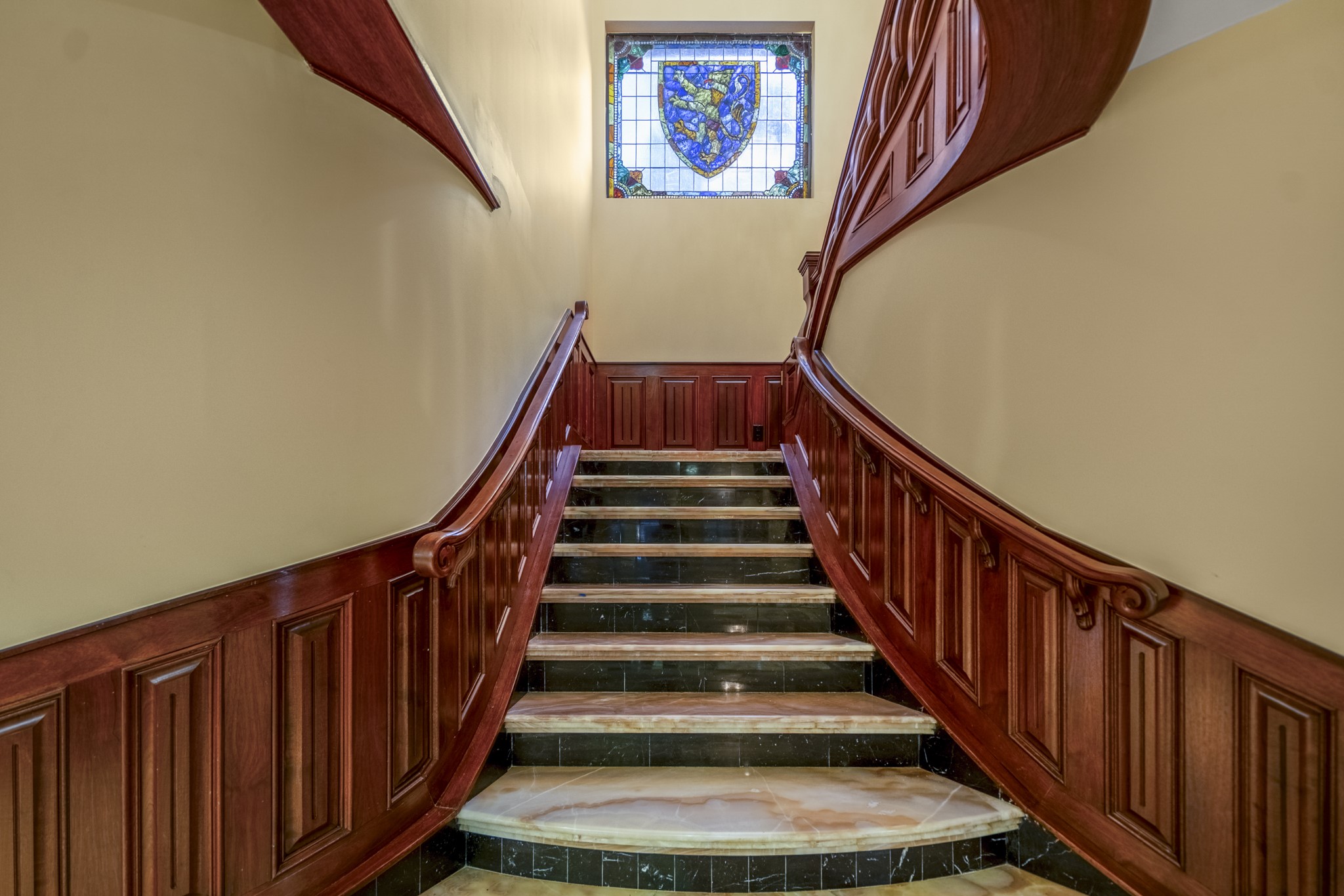 6535 Buffalo Speedway Houston, TX 77005 - Photo 23 of 40 The grand staircase is a true focal point, crafted with onyx and wood and illuminated by a round stained-glass window above.
