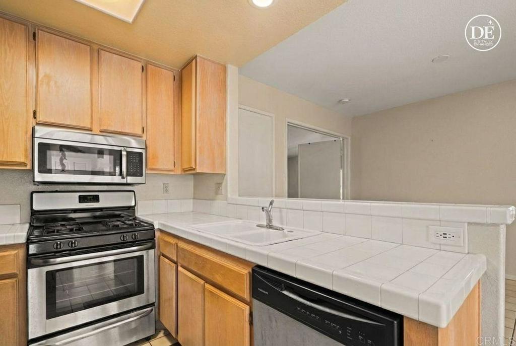 430 Stoney Point Way, Unit 129 Oceanside, CA 92058 - Photo 14 of 40 a kitchen with stainless steel appliances a stove cabinets and microwave
