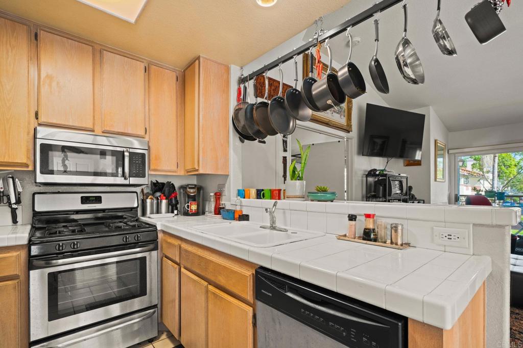 430 Stoney Point Way, Unit 129 Oceanside, CA 92058 - Photo 15 of 38 a kitchen with stainless steel appliances a stove a sink and a microwave
