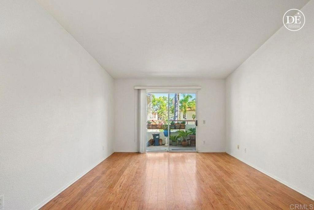 430 Stoney Point Way, Unit 129 Oceanside, CA 92058 - Photo 16 of 40 a view of an empty room with wooden floor and a window