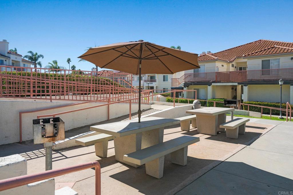 430 Stoney Point Way, Unit 129 Oceanside, CA 92058 - Photo 29 of 40 a view of a patio with a table and chairs under an umbrella