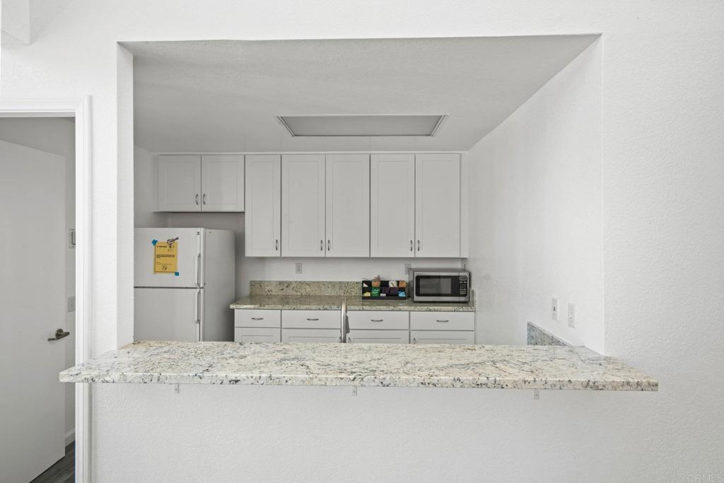 430 Stoney Point Way, Unit 129 Oceanside, CA 92058 - Photo 31 of 40 a kitchen with stainless steel appliances granite countertop a sink a stove and a refrigerator