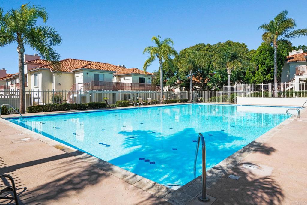 430 Stoney Point Way, Unit 129 Oceanside, CA 92058 - Photo 34 of 40 a view of a swimming pool with a lawn chairs under palm trees