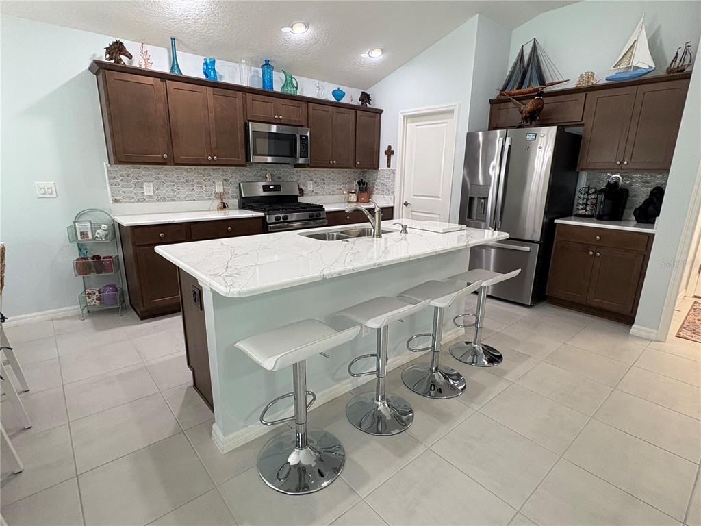 6370 Danielson Loop The Villages, FL 32163 - Photo 17 of 55 a kitchen with stainless steel appliances a stove a sink a microwave a refrigerator and cabinets