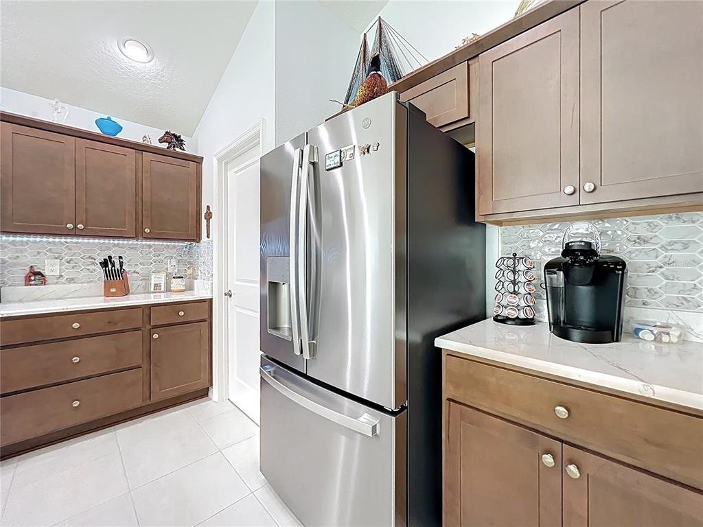 6370 Danielson Loop The Villages, FL 32163 - Photo 18 of 55 a kitchen with a refrigerator sink and cabinets