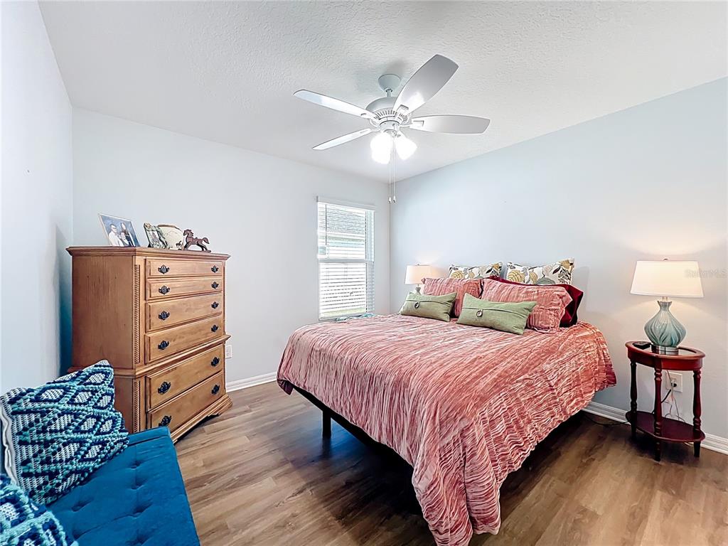 6370 Danielson Loop The Villages, FL 32163 - Photo 28 of 55 a bedroom with a bed and a chandelier