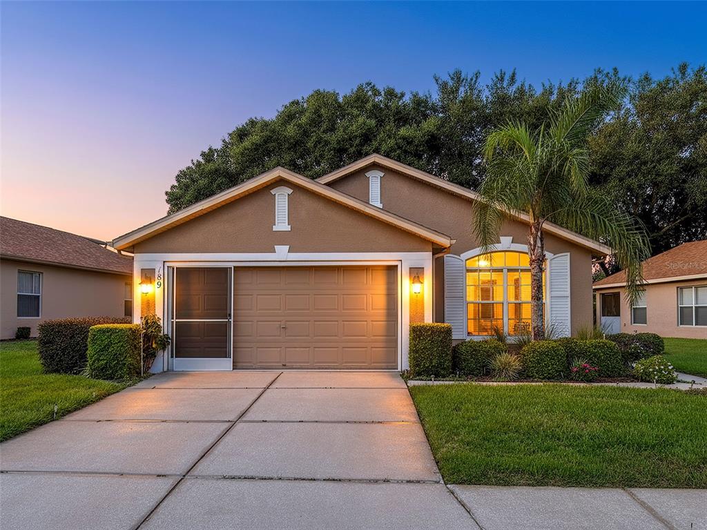 189 Center Oak Circle Spring Hill, FL 34609 - Photo 1 of 61 a front view of a house with a yard and trees