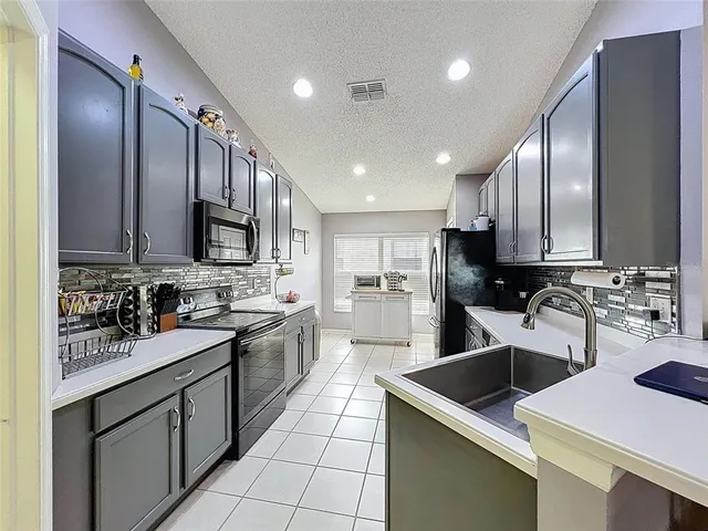 a kitchen with a sink a stove top oven and cabinets