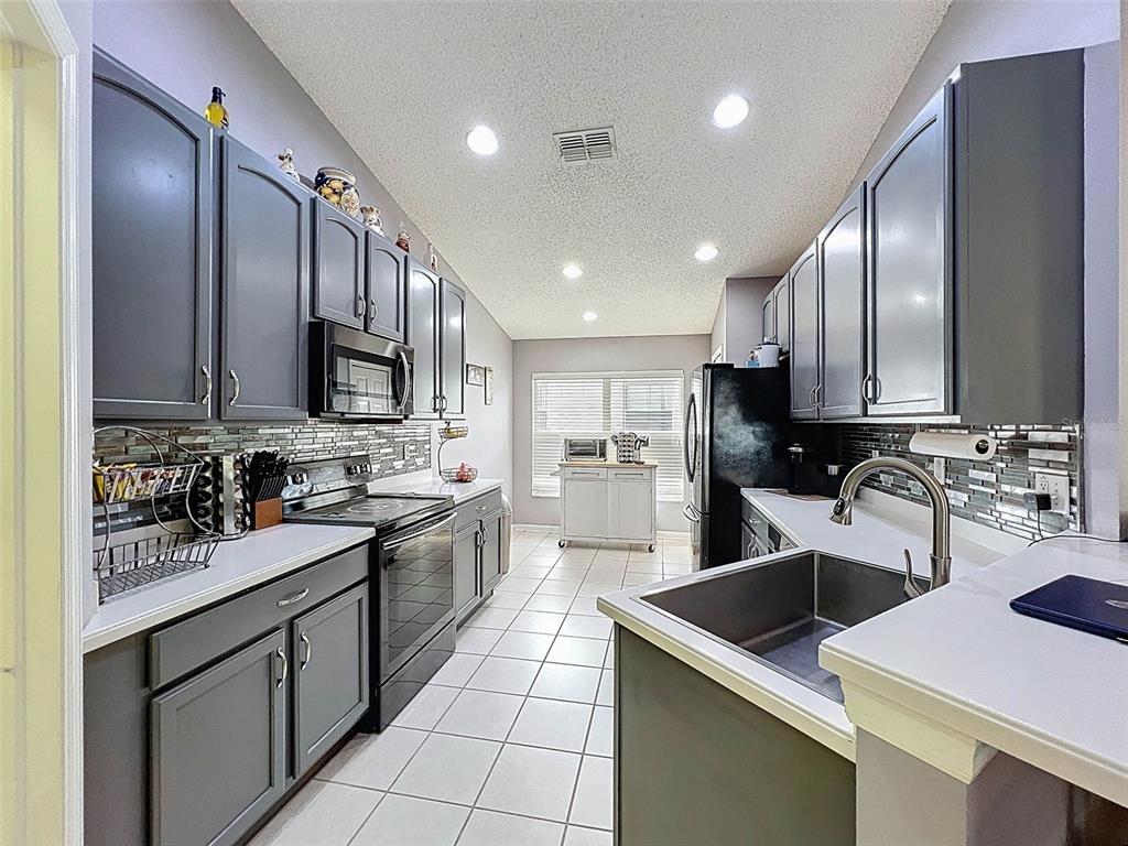189 Center Oak Circle Spring Hill, FL 34609 - Photo 13 of 61 a kitchen with a sink a stove top oven and cabinets