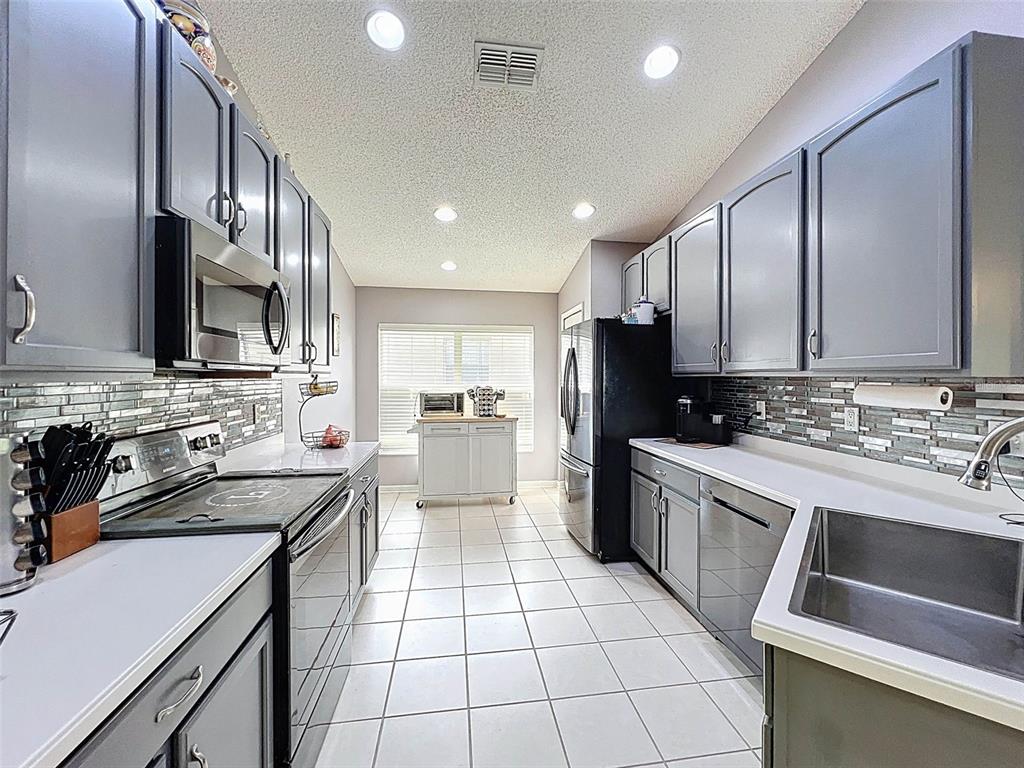 189 Center Oak Circle Spring Hill, FL 34609 - Photo 15 of 61 a kitchen with a sink a stove top oven and cabinets