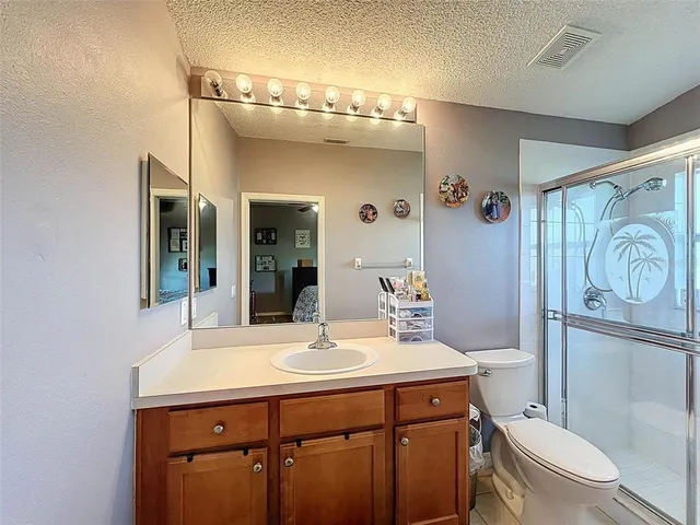 a bathroom with a granite countertop sink a large mirror and a shower