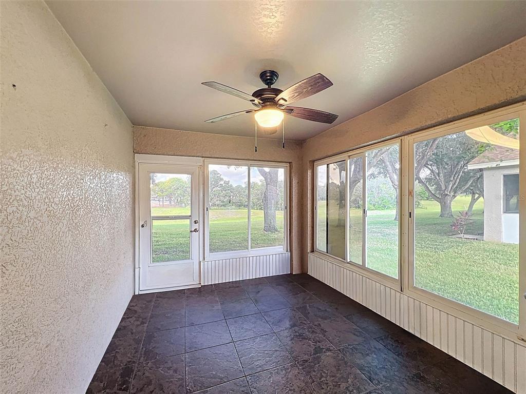 189 Center Oak Circle Spring Hill, FL 34609 - Photo 33 of 61 a view of an empty room with a floor to ceiling window and a ceiling fan