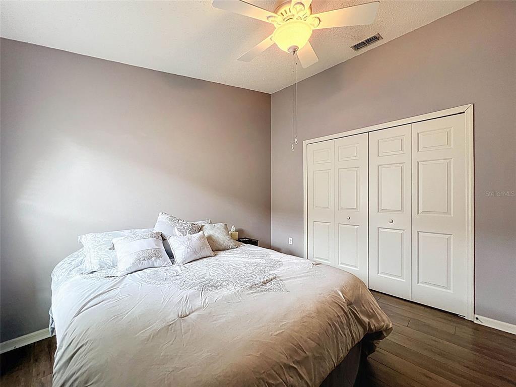 189 Center Oak Circle Spring Hill, FL 34609 - Photo 49 of 61 a bedroom with a bed and a chandelier