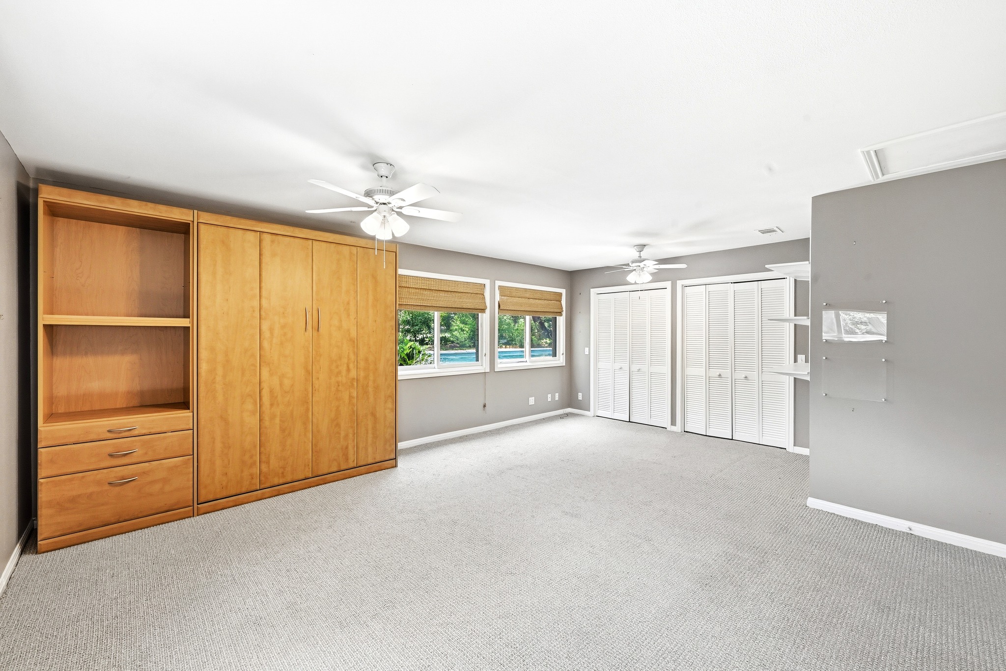 8608 Crest Ridge Circle Austin, TX 78750 - Photo 24 of 38 An airy bedroom with ceiling fans and ample built-in storage offers serene views through multiple windows.