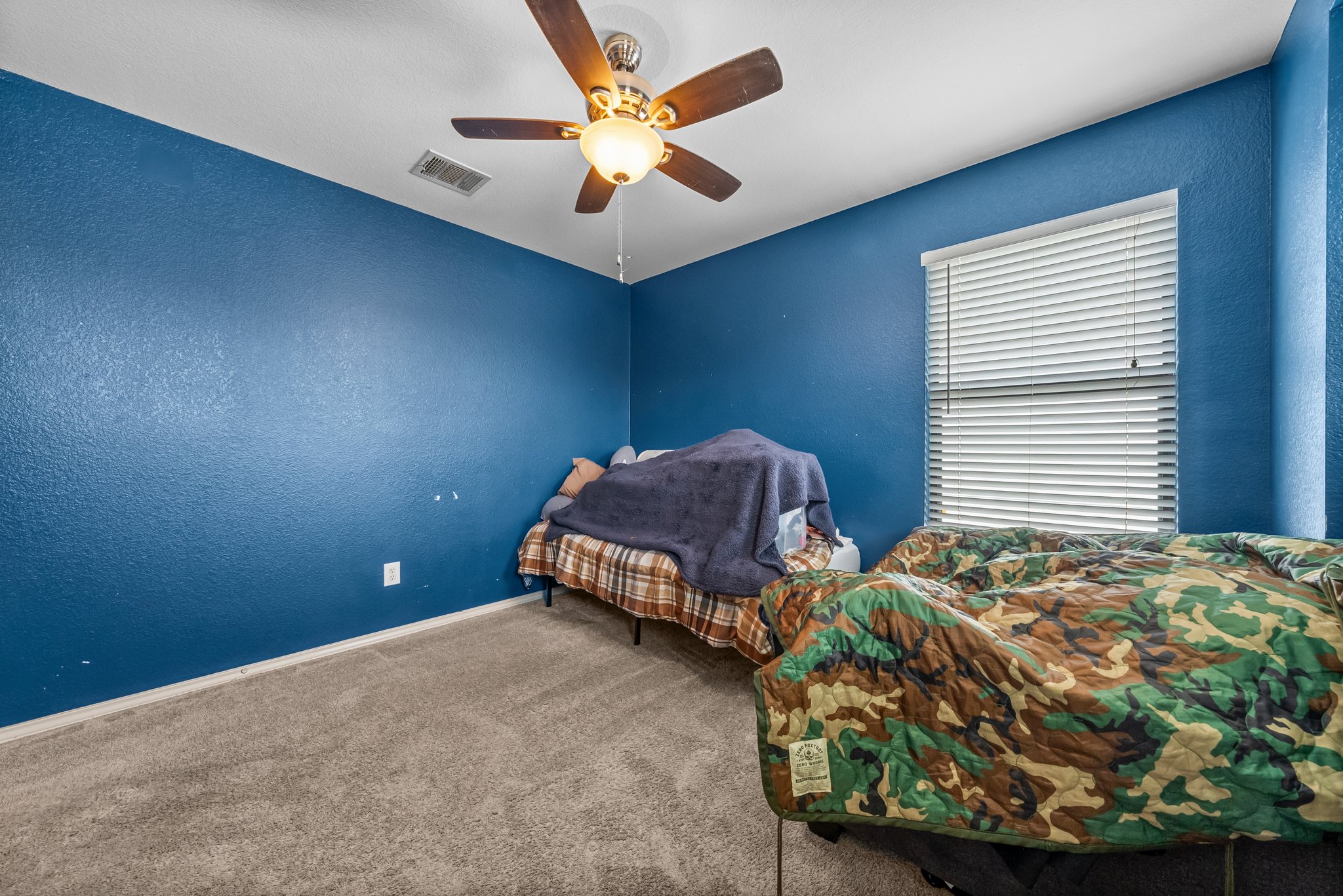 6829 Walkup Lane Austin, TX 78747 - Photo 11 of 18 A comfortable bedroom with carpeted floors and a ceiling fan for year-round comfort.