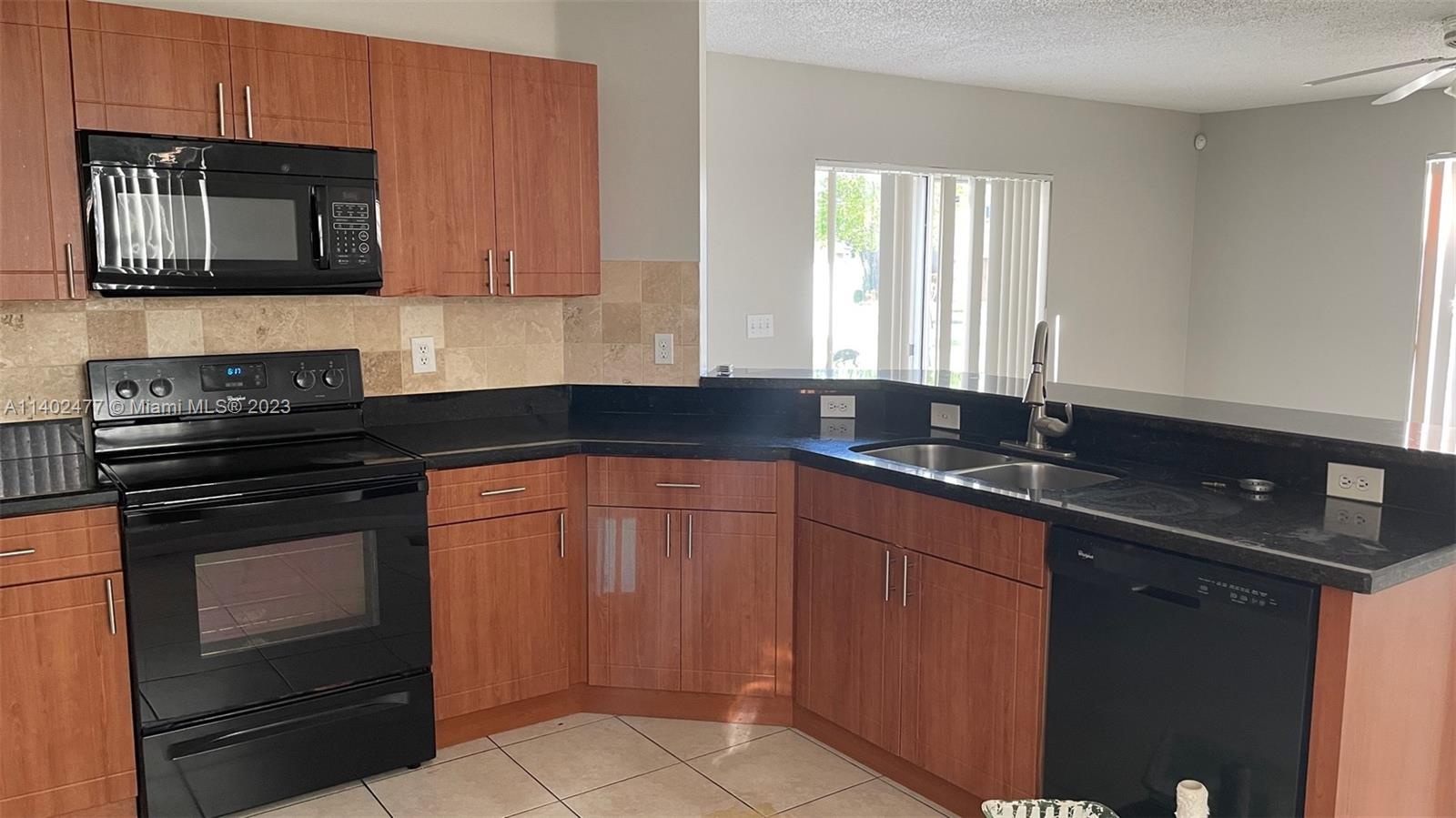Silver Lakes Miramar, FL 33029 - Photo 7 of 14 a kitchen with granite countertop wood cabinets stainless steel appliances and a sink