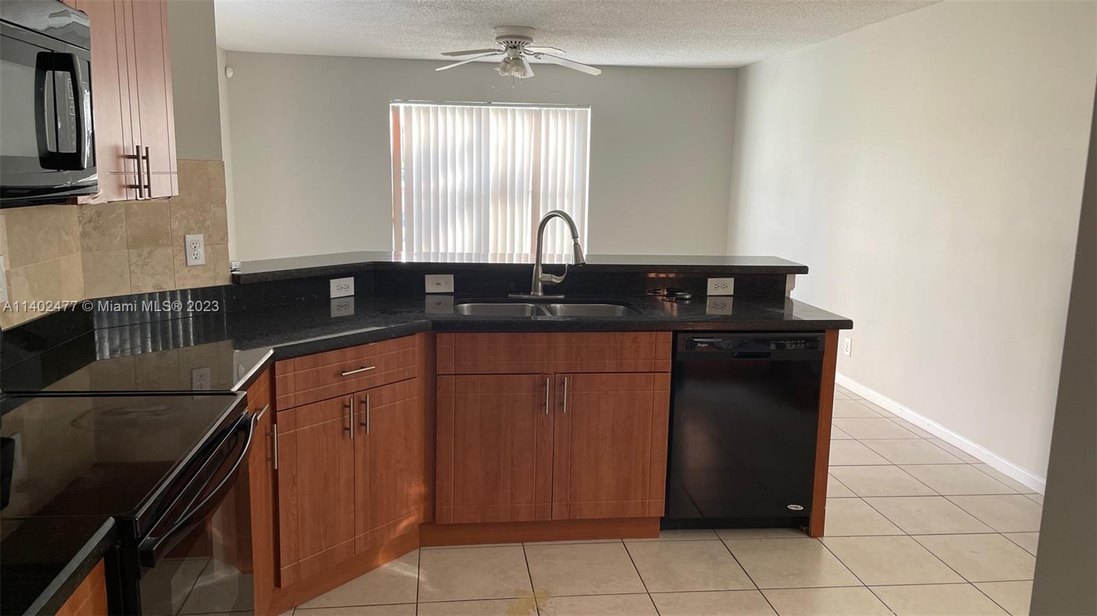 Silver Lakes Miramar, FL 33029 - Photo 8 of 14 a kitchen with a sink and a refrigerator