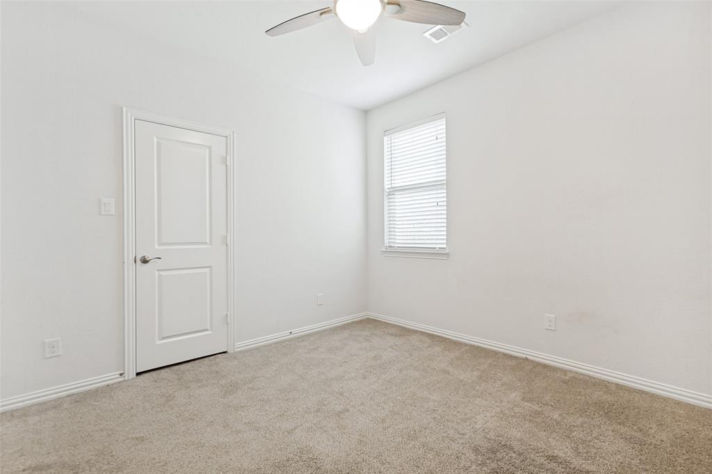 605 Ansley Way Allen, TX 75013 - Photo 22 of 28 Bright room featuring neutral-toned carpet, a white paneled door, a window with blinds, and a ceiling fan with light fixture