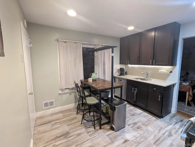 a room with a table chairs and a kitchen view