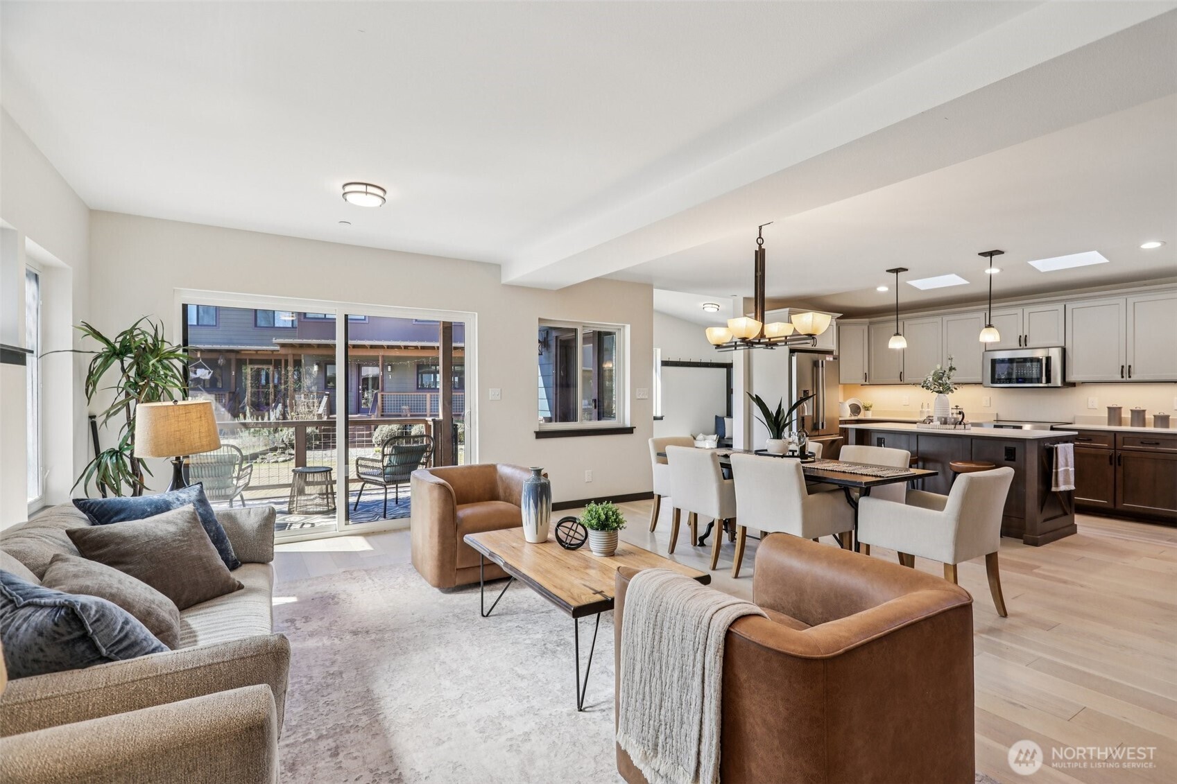 a living room with furniture kitchen view and a large window