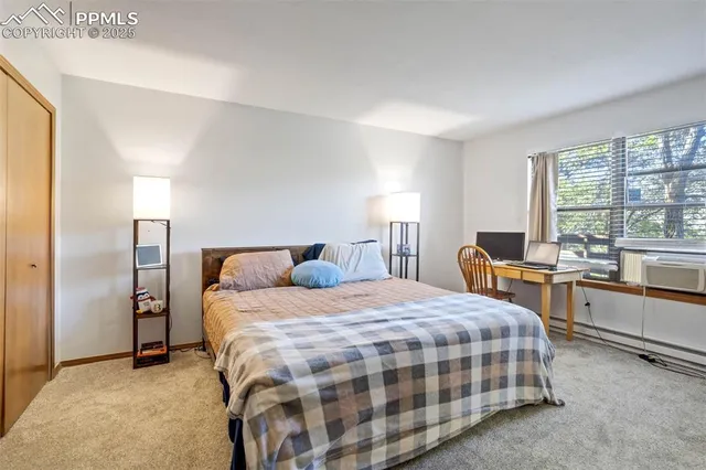a bedroom with a bed and large windows